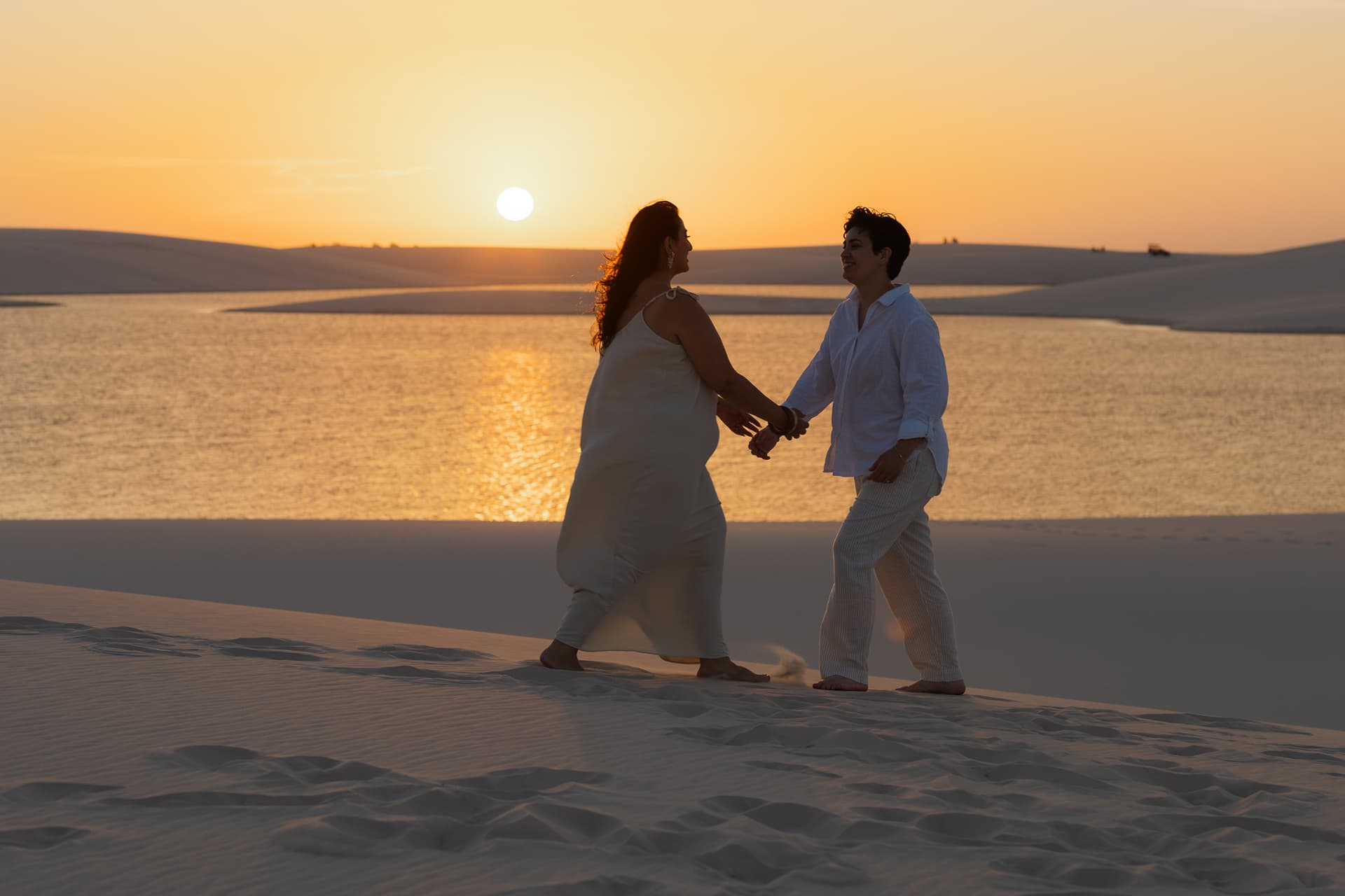 Amana e Julie, casal abraçado na luz dourada, Santo Amaro, Lençóis Maranhenses