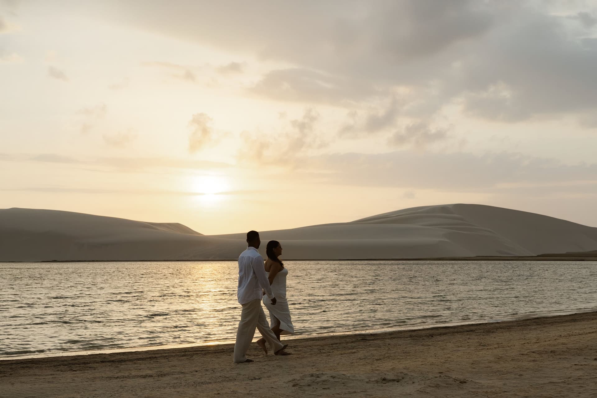 Casal na lagoa durante a golden hour nos Lençóis Maranhenses