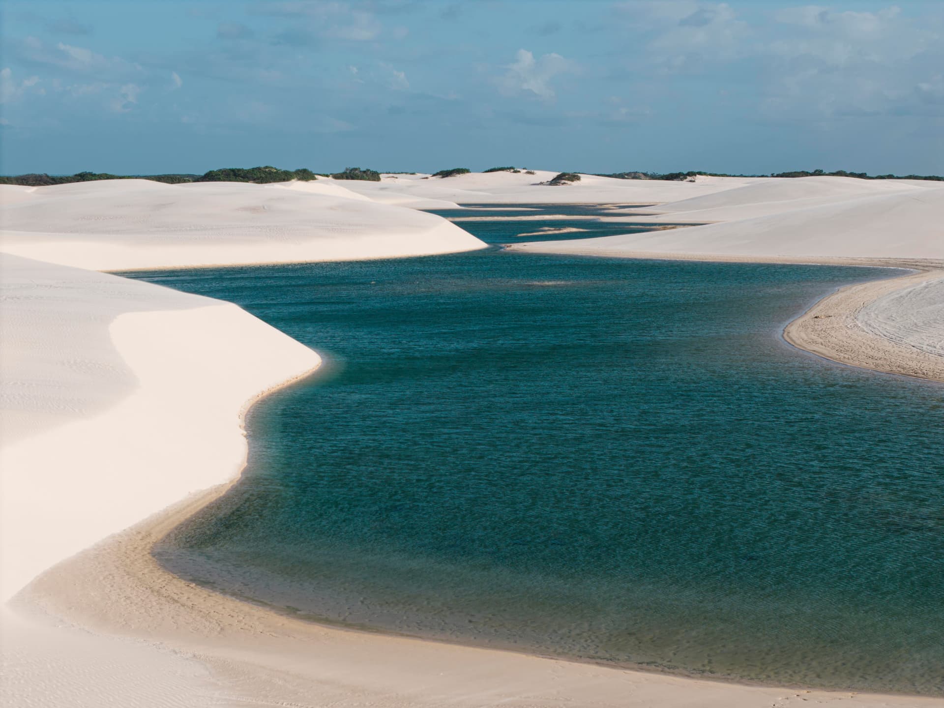 Lagoa azul cristalina entre dunas brancas em Atins, Lençóis Maranhenses