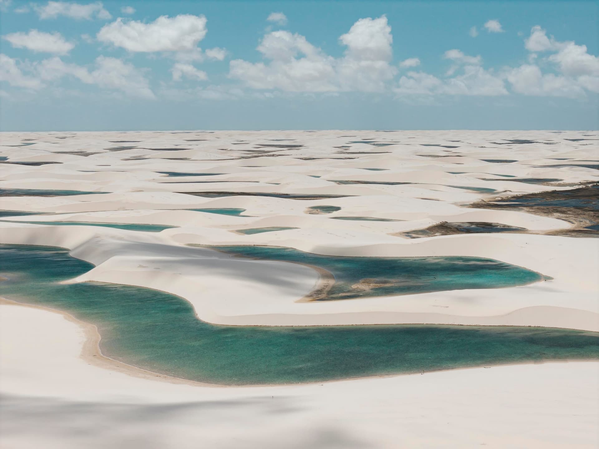 Lagoas turquesa entre dunas até o horizonte na região da Lagoa Bonita, Lençóis Maranhenses