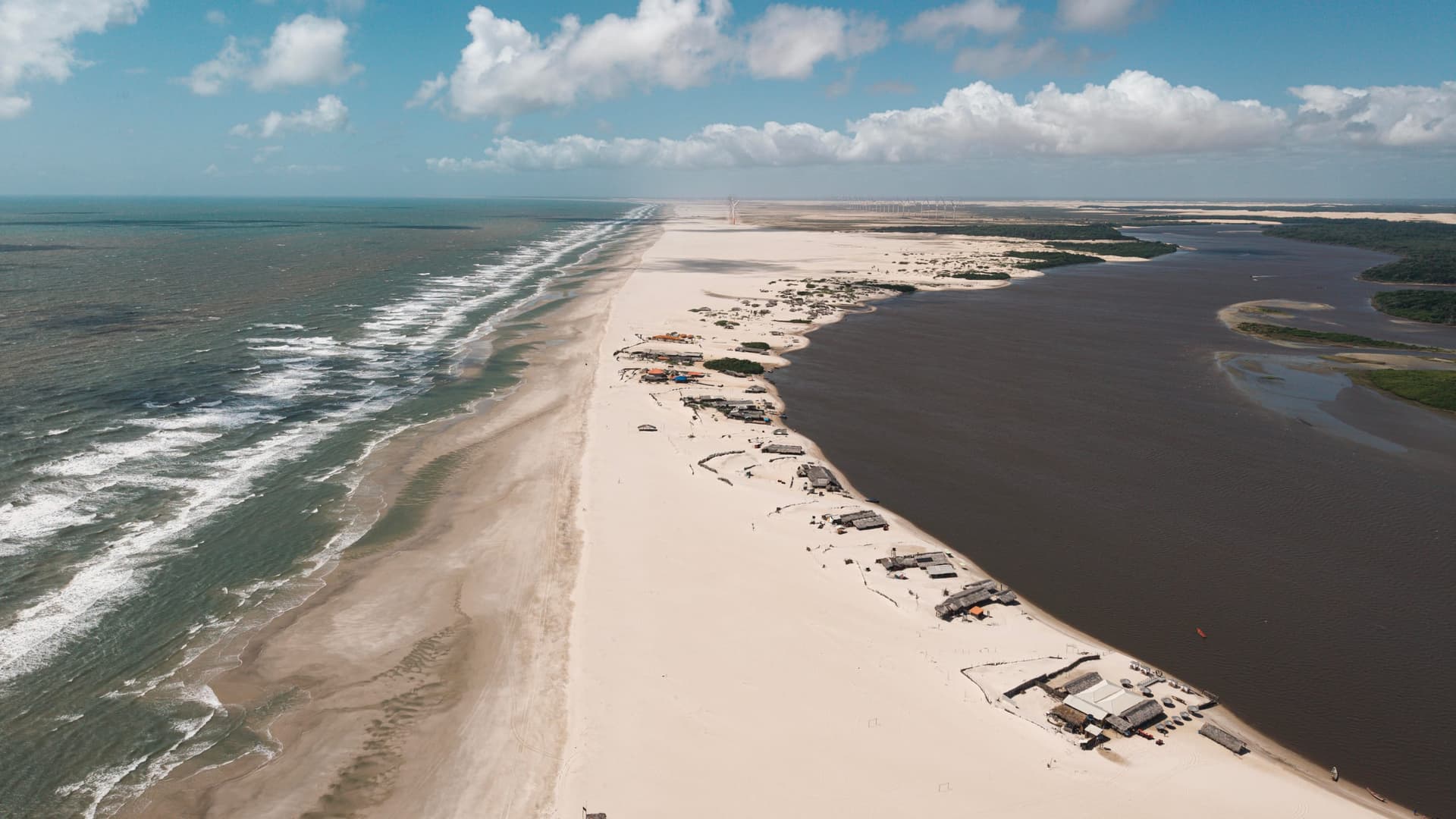 Caburé sand peninsula between the open sea and the Preguiças river, aerial view