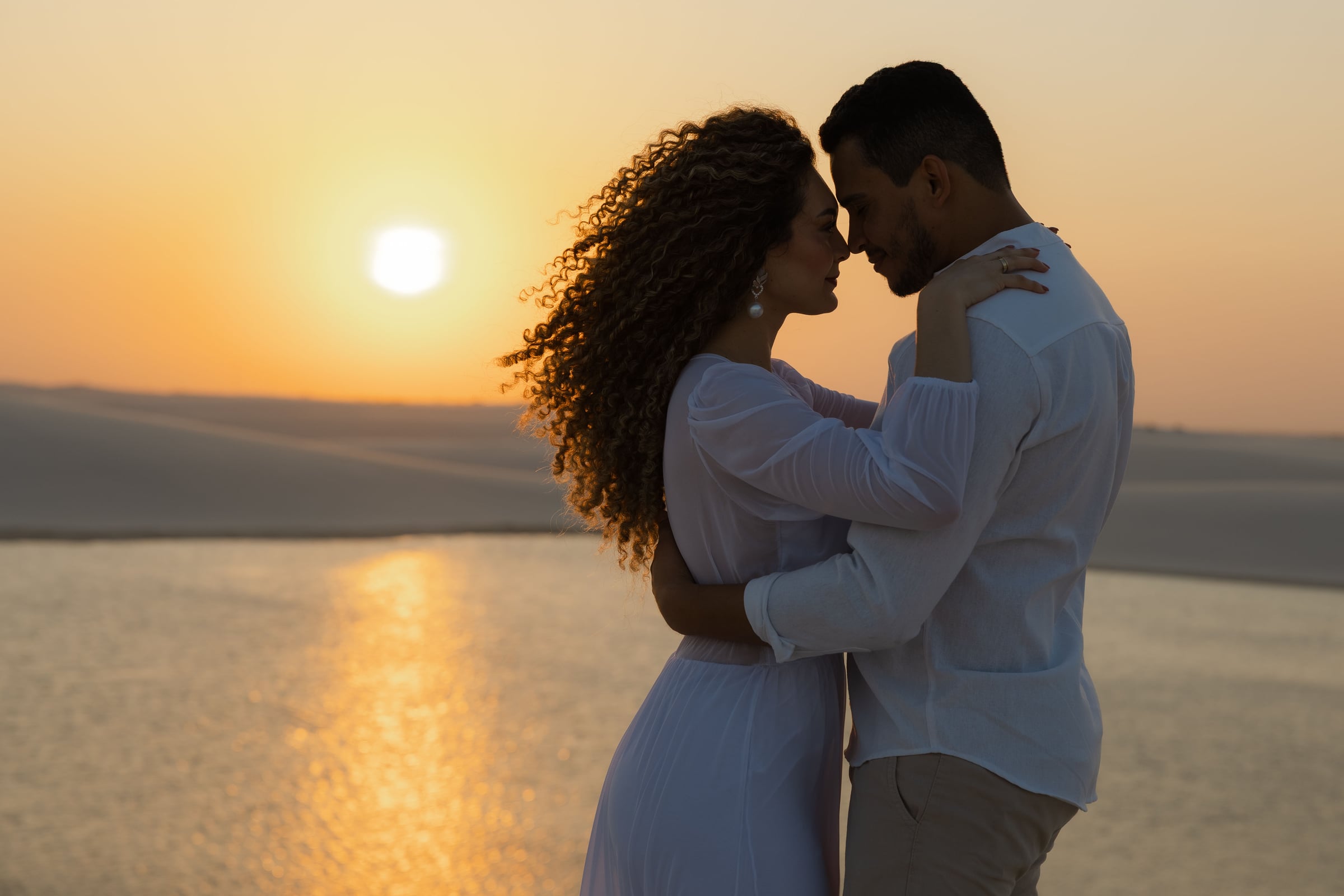 Ensaio romântico de casal na lagoa dos Lençóis Maranhenses ao pôr do sol